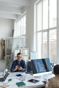 Male and female graphic designers interacting with each other at desk